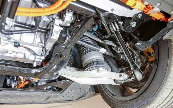 Както отпред, така и отзад, трансмисията използва междинни валове на изхода на едностепенните скоростни кутии (отляво по пътя). Тоест задвижващите колела са с еднаква дължина и водачът няма да се бори с теглене настрани по време на интензивно ускорение.

Окачванията са монтирани върху мощни стоманени подрамки, здраво закрепени към страничните елементи - освен това отпред има X-образна „носилка“, свързваща подрамката с корпуса на носещата батерия. Има адаптивни амортисьори отпред и отзад, а вместо пружини са поставени въздушни пружини, защитени от мръсотия чрез гофри. Приемникът и компресорът са разположени в задния надвес.

Архитектурата на предното окачване е подобно на Tesla Model S: две алуминиеви рамена (едното от които поддържа подпората) със сферични шарнири отдолу и друго отгоре. Задната комбинирана многораменна връзка (част от носачите са от щампована стомана) има конфигурация, подобна на тази на друга Tesla - Model 3.
