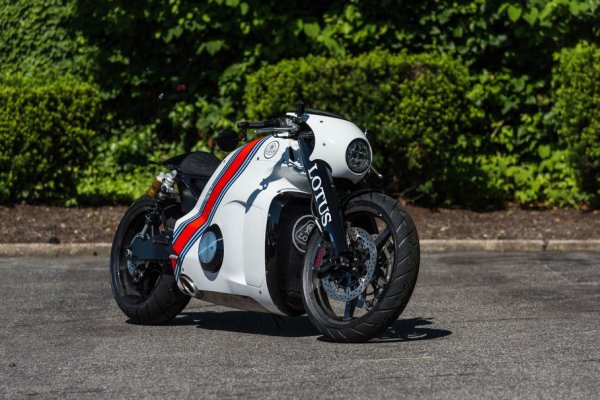 Ако се замислим за мотоциклет на Lotus, би трябвало да очакваме лек спортен модел с логото на славната британска марка или най-много някой нейкид. Но не и това... Всъщност, самата марка няма много пряка връзка с проекта С-01. Той е реализиран съвместно от немския състезателен отбор Kodewa Racing (сега ByKolles Racing) от Световния шампионат по издръжливост на FIA и техните сънародници Holzer Group с дългогодишен опит в автомобилния спорт. Като цяло не Lotus, а само име. По-точно брандиране.

Козът в екипа бил Даниел Саймън, бивш дизайнер на Volkswagen Group и създател на фантастични автомобили за филмовата индустрия. Саймън е създал кръстоска между крузър и масълбайк с масивна структура. Легендарната формула Lotus 49 от края на 60-те служи като източник на вдъхновение, въпреки че е трудно да се отгатне от дизайна. 