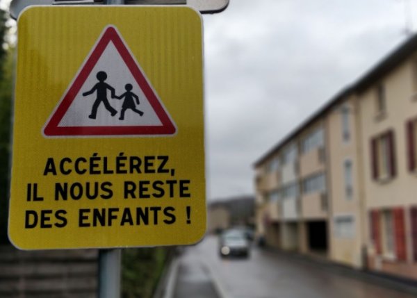 Този предупредителен знак във френското градче Люни гласи "Ускорете, останаха ни още малко деца". Идеята на местния кмет била чрез такива шокиращи послания да привлече вниманието на шофьорите и да ги подтикне наистина да намалят скоростта. 
