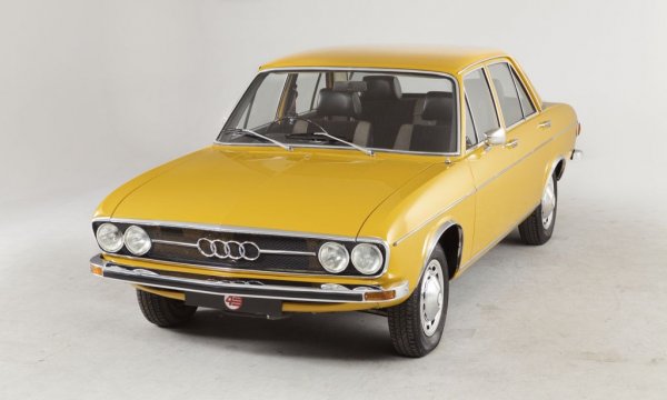 Audi 100 стана един от първите модели, пуснати на пазара, след като Volkswagen Group купи германската марка от Daimler-Benz. По това време основният приоритет на концерна беше да увеличи производството на VW Beetle. Ето защо появата на седан с разположен отпред двигател с течно охлаждане изглеждаше обречено на провал.