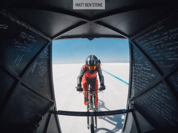 Постижението е дело на американката Денис Мюлер-Коренек, която се движи зад автомобил, за да преодолее съпротивлението на вятъра. Тя успява да развие 295,6 км/ч, като го постига с велосипед от карбон. Колелата са така проектиране, че с едно завъртане на педала да се изминават до 40 метра.