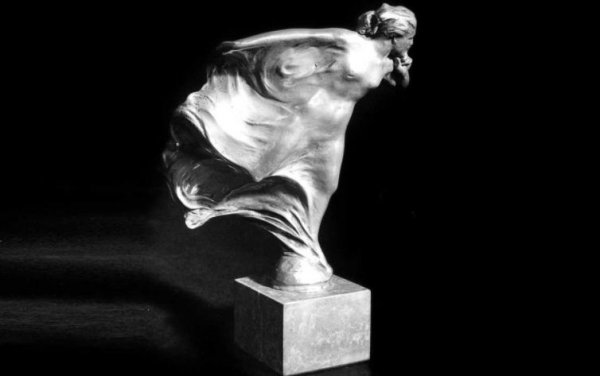 Оказва се, че направата на фигурката е поръчана от лорд Джон Дъглас-Скот Монтегю, който е собственик на автомобилното списание The Car Illustrated. Той е голям почитател на автомобилите и близък приятел на Чарлз Стюарт Ролс и Фредерик Хенри Ройс - основатели и притежатели на компанията.

Именно лорд Монтегю е първият човек в света който поставя на своя Rolls-Royce "Духът на екстаза". А първообраз на фигурката е неговата приятелка и секретарка в списанието Елеонор Валеско Торнтън.