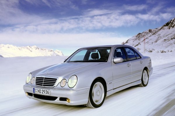 Работата по наследника на W124 започва още в края на 80-те. Дизайнът е на Стин Матин, под надзора на Бруно Сако. Ще запомним този автомобил като "четириочката" заради двата чифта кръгли фарове отпред. 
Известна с кода W210, тази Е-класа е по-голяма и доста по-луксозна от предишната. 
Това е първият Mercedes с ксенонови светлини с автоматично регулиране дължината на светлинния сноп.  
