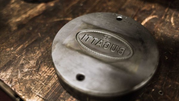 За да бъдем точни, всяко парче сребро .970 се щампова няколко пъти с натиск на пресата до 1000 тона. В резултат, буквите от емблемата на Bugatti са изпъкнали с 2,1 мм спрямо останалата част. Щамповането е предпочетено пред отливането, тъй като крайният резултат е по-заострен, по-детайлен и по-висококачествен продукт.