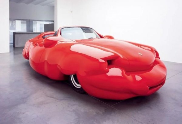 Ервин Вурм е доста нашумял австрийски скулптор, който прави поредица, озаглавена "Дебелите коли". Внушението е многопластово: акцент върху проблемите с наднорменото тегло, критика на консуматорското общество и каквото още ви хрумне. Под тази конкретна скулптура се крие истински автомобил - и то не какъв да е, а Porsche 911. 
