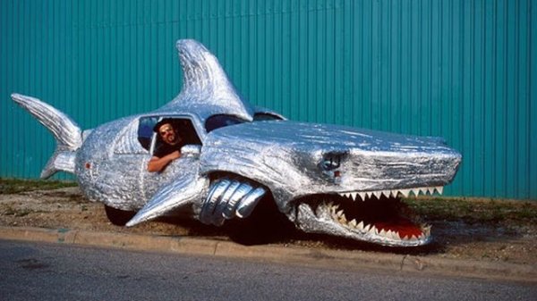 Том Кенеди е един от първите и най-популярни създатели на "арт" автомобили (така ги определя той самият). Акулата е от най-впечатляващите му творения - тя може да си отваря устата и да маха с опашка в движение. 
