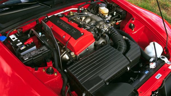 По времето, когато S2000 беше пуснат на пазара през 1999., Honda вече си беше изградила име като производител на едни от най-добрите двигатели с атмосферно пълнене. Да, системата за променливо газоразпределение (V-Tec) беше отговорна за впечатляващата мощност във върховите обороти, но както BMW, така и Porsche имаха по-усъвършенствани системи за променливо газоразпределение в продължение на години; именно ненадминатата надеждност и този тласък при размяната на лобовете на разпределителния вал дадоха на двигателите на Honda статут на емблема.


S2000 вдигна летвата, осигурявайки най-много конски сили на литър от всички сериен автомобил до този момент и предлагайки интензивно шофиране, което беше трудно да се сравни. Автомобилите със спецификации за САЩ получиха 2,2-литров двигател с по-голям въртящ момент от 2004 нататък, но за сметка на част от маниакалната оборотност на 2,0-литровия агрегат.