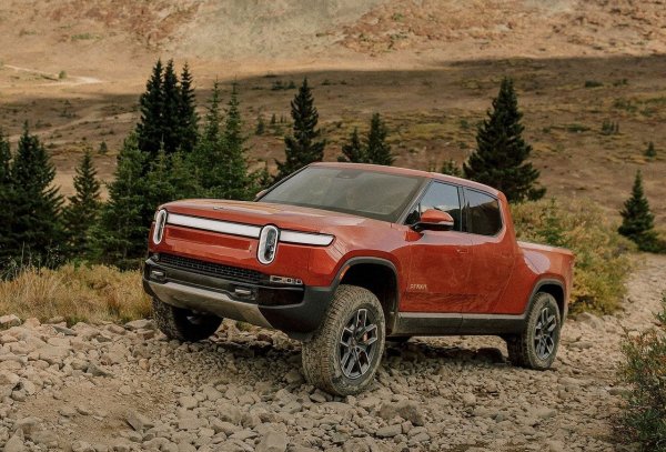 Докато Илон Мъск строеше стерилен свят на бъдещето върху перфектен асфалт, Rivian изведнъж излезе от сенките и доказа, че електрическите коли могат да имат душата на авантюрист. Компанията се появи през 2009 от нищото и не спазваше правилата на старата школа, като беше първата в света, която пусна масово произведен електрически пикап, оставяйки гиганти като Ford и Chevrolet в ролята на наваксващи изоставането си.