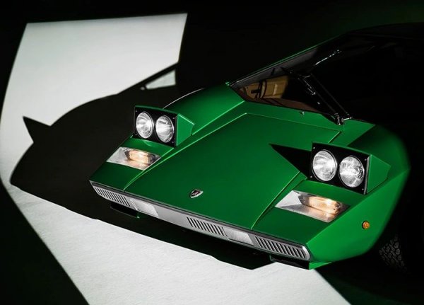 Марчело Гандини, гениалният дизайнер зад Countach, разказа преди време истинската история на името. "В ателието Bertone имаше майстор, който изработваше ключалките. Беше двуметров, с гигантски ръце, и говореше само пиемонтски. Всяка втора дума му беше "Кунташ!"... Една нощ, докато бързахме да довършим модела, подхвърлих на майтап, че можем да го кръстим Countach. Само се шегувах, но Боб Уолъс, който сглобяваше механиката, вдигна глава и каза: "по странен начин това работи". Веднага измислихме шрифта и името се задържа". 
