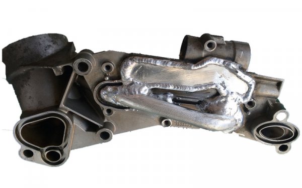 Уплътненията на топлообменника никак не са скъпи - трийсетина лева. Но самата им смяна е мъчна и трудоемка. При по-стари машини често майсторите предлагат просто да заварят каналите, за да ви избавят от подобни проблеми в бъдеще (на снимката). Естествено, топлинната ефективност на двигателя страда от това, но някои предпочитат това решение като по-малкото зло. 
