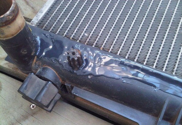 Особено сериозен проблем в най-горещия период на годината, водещ до опасно повишаване на работната температура на двигателя. Не е нужно да чакате изпод капака да се появи облак пара, за да установите проблема - водниста локва под предния капак подсказва за утечка, както и видимо намалялото ниво на охладителна течност в преливника. 
За да закърпите положението на място, трябва първо да изчакате двигателя на изстине - и то доста търпеливо, защото не става за няколко минути. Ако имате възможност, след това изплакнете радиатора с маркуч, за да имате по-добър шанс да видите къде е пробивът. След като почистите, стартирайте двигателя и гледайте внимателно за теч. 
Ако успеете да видите откъде тече, по-добре е да се опитате да го залепите със специално епоксидно лепило, каквито се продават по бензиностанциите. Съдържащо епоксидна смола и полимери, то може успешно да спре течовете, но го оформете в достатъчно дебел слой, за да издържи на вътрешното налягане в радиатора.

