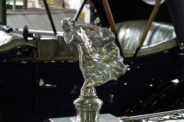 Шепотът, до голяма степен смятан за вдъхновение за орнамента "Духът на екстаза", е замислен от скулптора Чарлз Сайкс за Rolls-Royce Silver Ghost от моделната 1909 година, принадлежащ на неговия покровител, втория барон Монтагю от Болю. Моделът за орнамента, Елинор Веласко Торнтън, е била любовницата на Монтагю. Историята разказва, че пръстът, държан до устните ѝ, е показвал тайна, която трябвало да бъде запазена.
