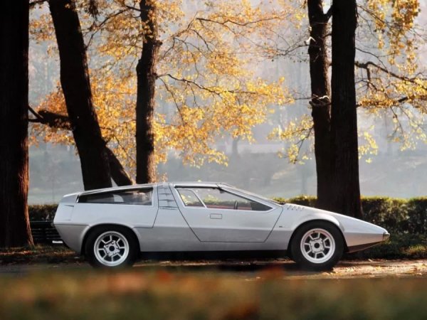 Porsche, уморена да чува упреци, че от десетилетия прави един и същ "балон" със задно разположен двигател, позволява на майстора да експериментира с платформата 914/6. Така се появява Tapiro - удължен, заострен и драматичен.

Под ъгловатите панели се намира 2,4-литров боксерен двигател с мощност 220 к.с., което не е сензация по стандартите на 70-та година, но е повече от достойно. Основното не е в цифрите, а във външния вид. Пропорциите са сякаш директно от Модена: нисък силует, много дълъг преден капак, къса задна част и агресия, все едно, че колата е длъжна да участва в научнофантастичен филм за колонизацията на Луната.
