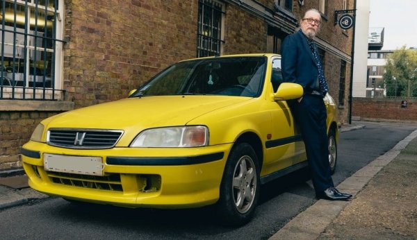 Колата, която свързваме с най-актуалната роля на сър Гари - като шпионина Джаксън Ламб в хитовия сериал Slow Horses. Старичкият Civic с 1.4-литров мотор е екранният автомобил на Ламб. "Вътре още има боклуци от първия сезон, който снимахме преди пет години. На места растат гъби", смее се Олдман. "Най-много карах в първия сезон, хубаво беше наистина да карам, а не да се преструвам. Смяната на предавките е много гладка. И изобщо няма нищо по-хубаво от това да караш стара кола. Особено когато не е твоя". 
