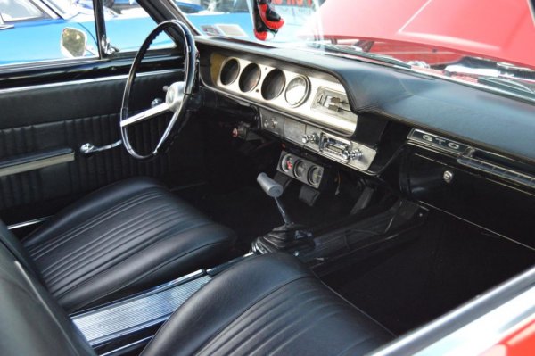 Този автомобил има потресаващо добър външен вид, както и достатъчно мощност, за да изправи косите и на най-големите смелчаци през 60-те в Щатите. Нещо повече, автомобилът си изгражда лоша репутация, която обаче в този сегмент е нещо хубаво. Как се случва това, ли? Много просто. Името му е откраднато от Ferrari.
Колкото до характера на автомобила, Pontiac GTO, който между другото е нарисуван от Джон Делорийн, няма нищо общо с именития си италиански колега Ferrari 250 GTO. Колата от Маранело е създадена за състезателни цели, докато американската машина е по-подходяща за каране по широка и права магистрала от човек с каубойска шапка и карирана риза с навити ръкави.
