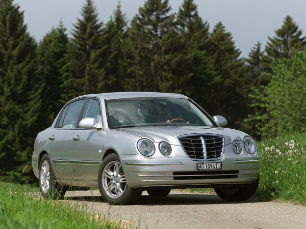 Този корейски бизнес-седан (2003-2010 г.) с двигатели V6 прекалено много приличаше на Mercedes-Benz E-Class особено в предната си част. Автомобилът беше приятен за каране, комфортен и надежден, но му липсваха именно характер и индивидуалност.

Всъщност, именно благодарение на Opirus в Kia най-после проумяха, че трябва да залагат повече на дизайна и на интериора, за да може автомобилите на марката да получат индивидуалност и да бъдат харесани. Така се появи наследникът Cadenza, който вече не приличаше толкова на Mercedes.  