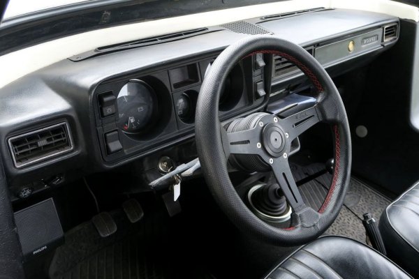 Интериорът е спартански, но това не би учудило никой собственик на Лада. Има въздушни отвори, които се движат наляво и надясно, има оставена ниша за радиокасетофон, има огледало за обратно виждане. И понеже говорим за 80-те години, има един пепелник отпред... и още два пепелника отзад. 
