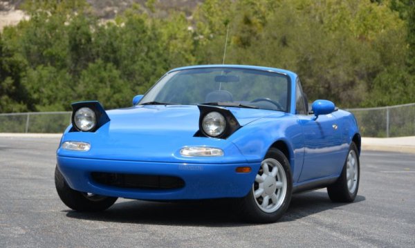 Още през 50-те американците развиха слабост към британските открити спортни коли. Но през 70-те и 80-те британската автомобилна индустрия се самоунищожи и остави вакуум. Който накрая бе запълнен от една японска кола, но с британска душа. Носеща отчетливи прилики с оригиналния Lotus Elan, Mazda MX-5 имаше обаче и козове, с каквито никоя английска машина не е разполагала: например двигател, който пали всеки път, когато завъртиш ключа. Или технически течности, които си стояха в колата, а не по асфалта на паркинга или пода на гаража ви. 
С нищожно тегло, доста напредничаво окачване и фантастично директно управление, тази Mazda ни върна чистата радост от шофирането. В ревюто си C/D го описа така: тя е като най-симпатичното куче на света - смееш се с него, играеш си с него и накрая се чувстваш доста по-добре. 

