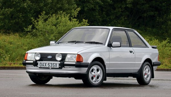 Golf GTI вече е създал сегмента на хот хечовете, и инженерите на Ford също искат част от овациите в него. Докато предишните генерации на Escort имат специализирани рали версии, идеята е третото поколение да има върхов модел, достъпен за максимално широк кръг от хора. Първо се появява Escоrt XR3, с тунингован 1.6-литров мотор с двоен карбуратор Weber, подсилено окачване и разни дребни разлики в екстериорния дизайн. След това през октомври 1982 дебютира и версията с инжекцион - XR3i, а след това - и лимитираната версия RS 1600i, развиваща 115 коня. 
