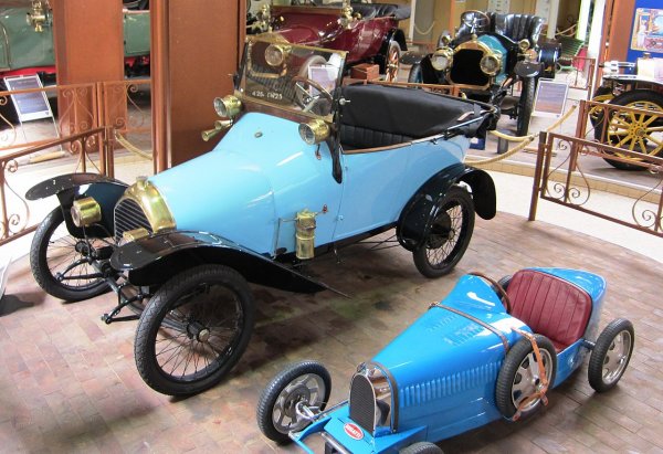 През 1904 Peugeot представя в Париж революционен компактен модел, наречен Bebe. Втората му генерация от 1912 е проектирана от самия Еторе Бугати - по онова време още млад конструктор. Дизайнът носи характерния почерк на Еторе, който после ще открием в собствената му марка (на снимката е Bebe редом с детска количка Bugatti - приликите са очевидни).